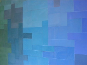 mosaico hidráulico de vários tons de azuis e verdes em  formatos diversos aplicado numa tampa de uma mesa. O design é da Mette Laerke da Projecto Mosaico