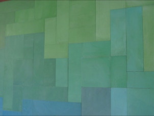 mosaico hidráulico de vários tons de azuis e verdes em  formatos diversos aplicado numa tampa de uma mesa. O design é da Mette Laerke da Projecto Mosaico